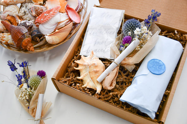 sailormade message in a bottle with calligraphy note, bouquet of dried flowers, true lovers knot bracelet and sea shell