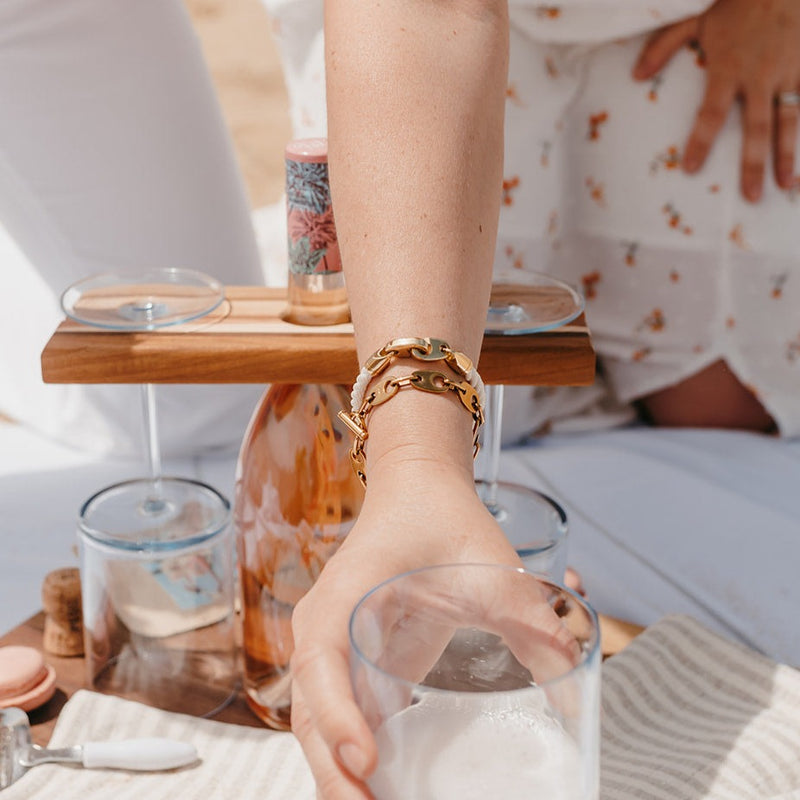 Wine cheers on Plum Island wearing Sailormade nautical women’s bracelet stack with rose gold single wrap rope brummel bracelet in white and a brummel link chain bracelet in rose gold.