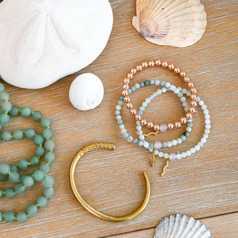 Sackable Rayminder UV Awareness bracelets for sun safety and uv protection in rose gold, aquamarine, and jade with women's slim fid cuff and sea glass frosted beaded necklace