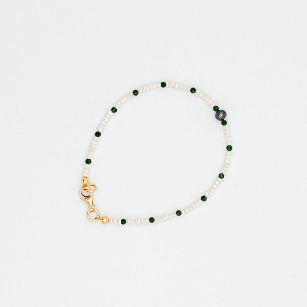 Mini freshwater pearls with green quartz rondelle beads and a black pearl in the center give this beautiful bracelet a clean and modern look.