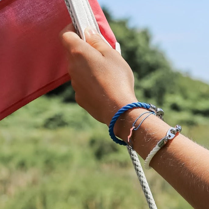 Woman raising usa flag wearing sailormade nautical marine rope bracelets with Stainless steel brummels.