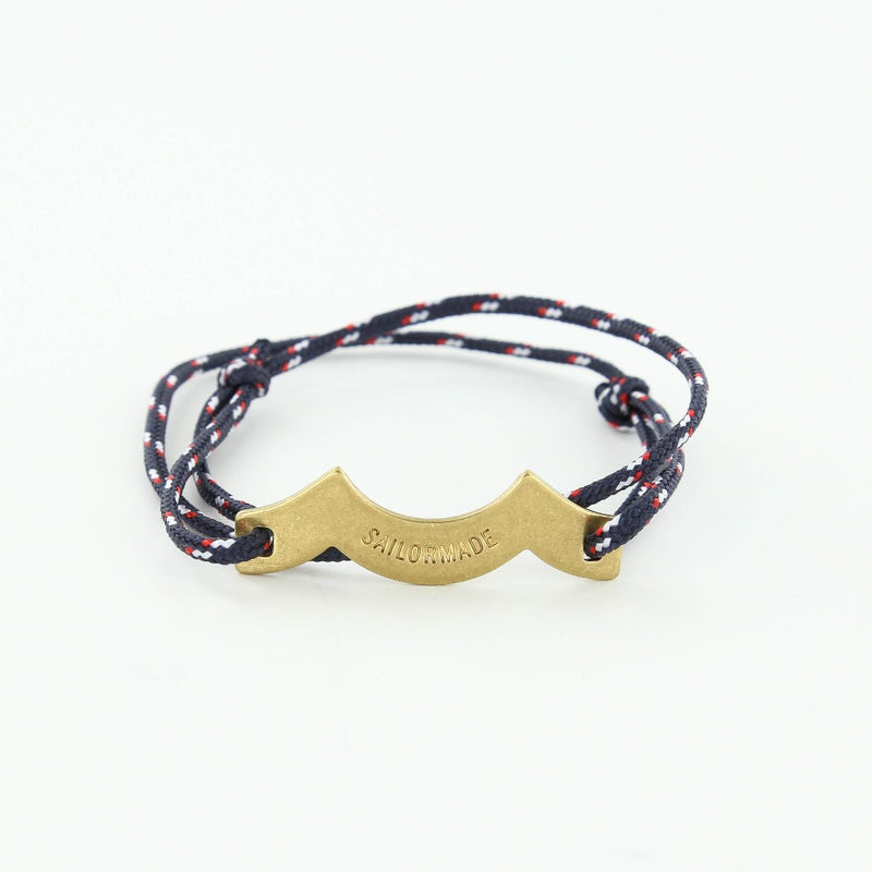 Sporting slip knot rope bracelet with brass wave charm in navy, red, white. Made in Boston.