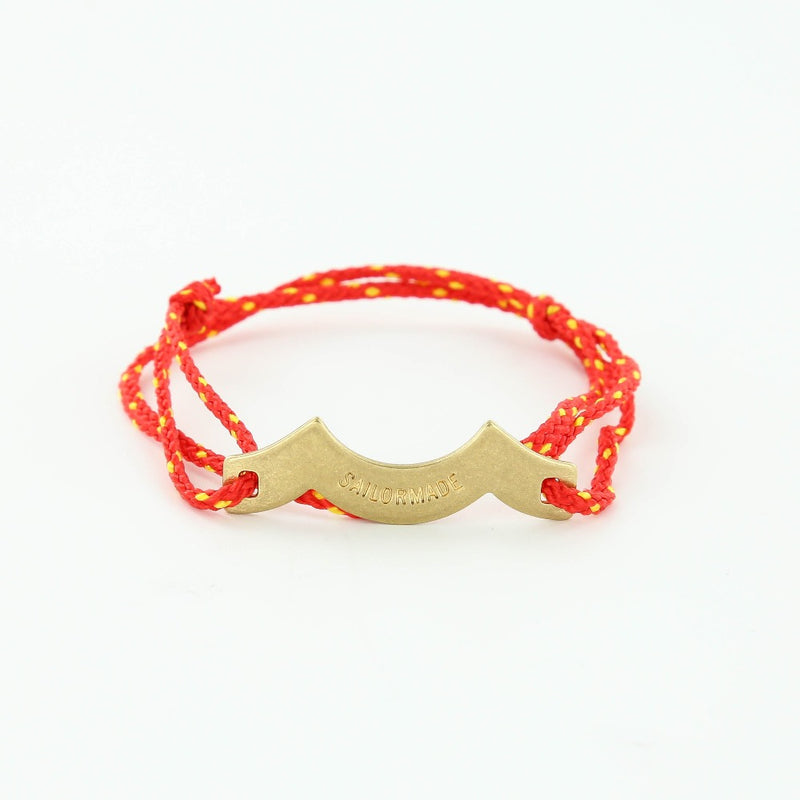 Sporting slip knot rope bracelet with brass wave charm in red and yellow. Made in Boston.